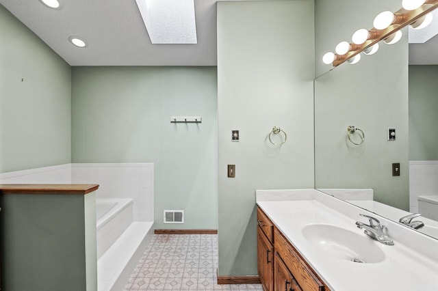 13838 Glendale Trl, Savage, MN 55378 - bathroom featuring a bath, vanity, recessed lighting, a textured ceiling, and a skylight