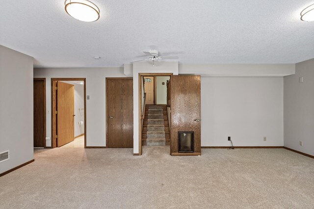 13838 Glendale Trl, Savage, MN 55378 - unfurnished living room featuring a textured ceiling, carpet floors, stairs, and ceiling fan