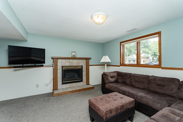 3714 8th St NW, Rochester, MN 55901 - carpeted living room featuring a tile fireplace, wainscoting, a textured ceiling, and wood walls