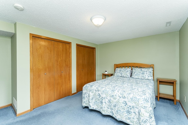 3714 8th St NW, Rochester, MN 55901 - bedroom with carpet floors, multiple closets, and a textured ceiling