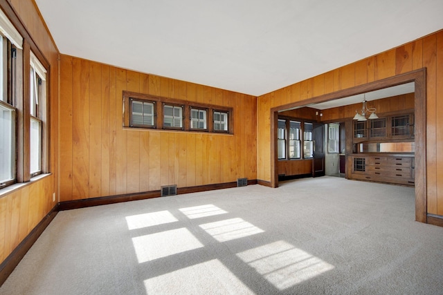 3736 Park Ave, Minneapolis, MN 55407 - carpeted spare room featuring wooden walls and a chandelier