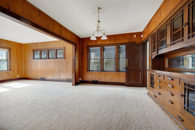 3736 Park Ave, Minneapolis, MN 55407 - unfurnished room with wood walls, carpet, and a chandelier