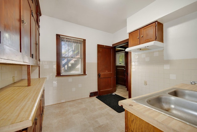 3736 Park Ave, Minneapolis, MN 55407 - kitchen featuring tile walls, under cabinet range hood, and wainscoting
