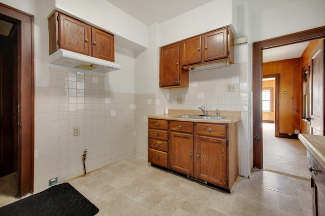 3736 Park Ave, Minneapolis, MN 55407 - kitchen featuring under cabinet range hood, tile walls, light countertops, brown cabinetry, and light tile patterned floors