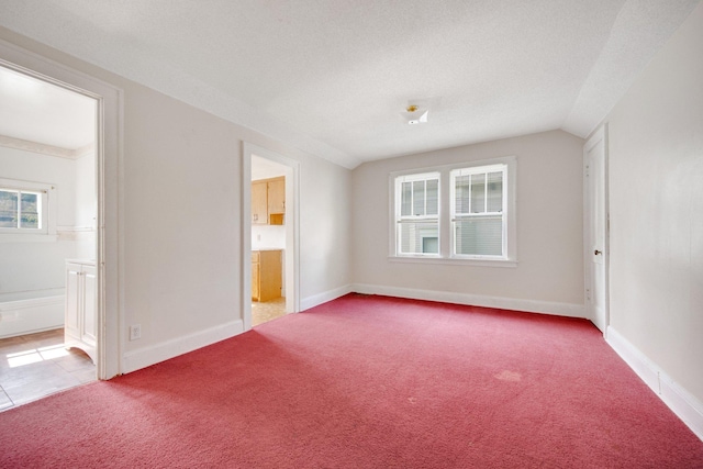 3736 Park Ave, Minneapolis, MN 55407 - unfurnished bedroom with light carpet, connected bathroom, and vaulted ceiling