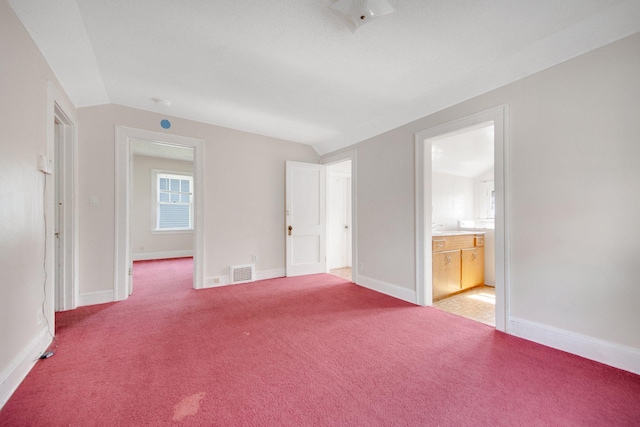 3736 Park Ave, Minneapolis, MN 55407 - unfurnished bedroom with vaulted ceiling, light colored carpet, and connected bathroom