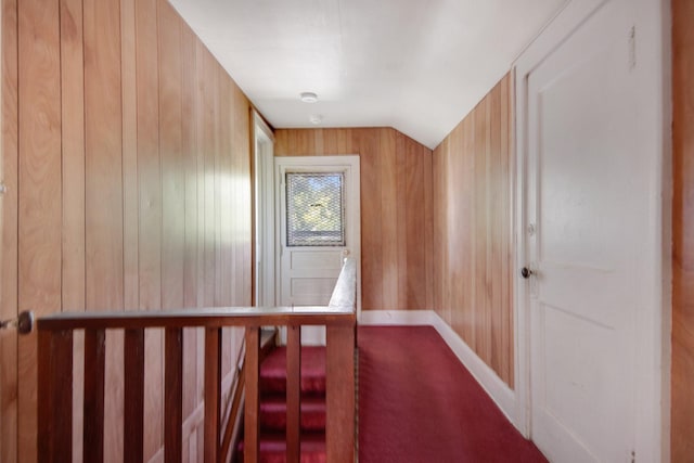 3736 Park Ave, Minneapolis, MN 55407 - hallway with dark carpet, wood walls, and vaulted ceiling