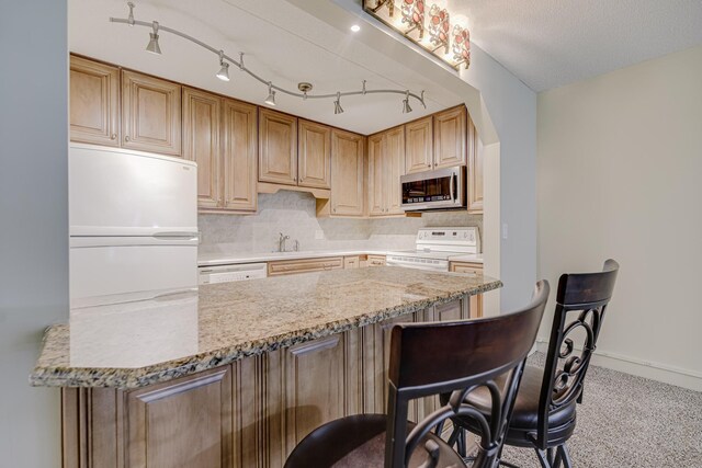 10521 Cedar Lake Rd Unit 208, Minnetonka, MN 55305 - kitchen with white appliances, a breakfast bar, carpet floors, decorative backsplash, and light stone counters