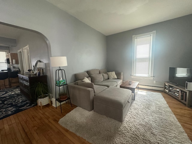713 2nd St NE, Minneapolis, MN 55413 - living room with wood finished floors, plenty of natural light, arched walkways, and a baseboard heating unit