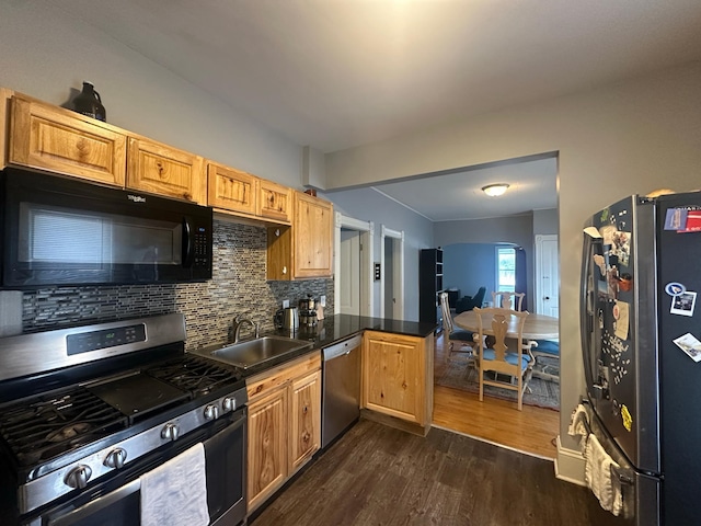 713 2nd St NE, Minneapolis, MN 55413 - kitchen featuring stainless steel appliances, dark wood-style flooring, a peninsula, tasteful backsplash, and dark countertops