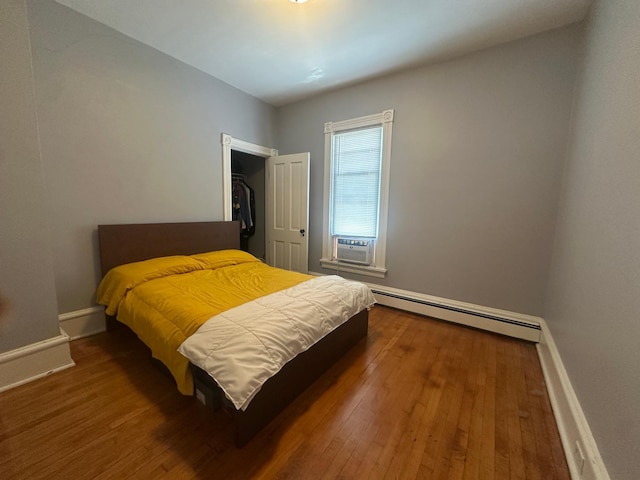 713 2nd St NE, Minneapolis, MN 55413 - bedroom featuring a baseboard heating unit, hardwood / wood-style flooring, cooling unit, and a closet