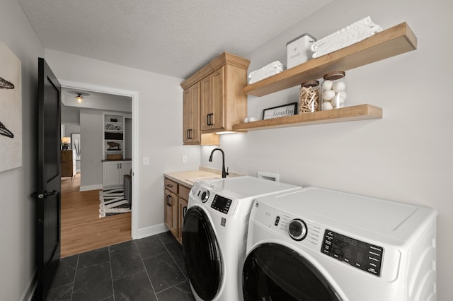 1162 Woods Creek Dr, Delano, MN 55328 - laundry room featuring washer and clothes dryer, cabinet space, dark marble finish floors, and a textured ceiling