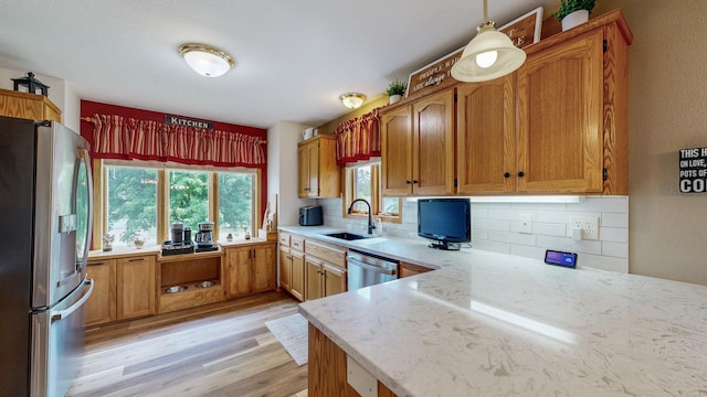 1057 John And Mary Dr SE, Chatfield, MN 55923 - kitchen featuring appliances with stainless steel finishes, light wood-type flooring, backsplash, and brown cabinets