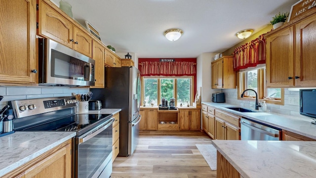 1057 John And Mary Dr SE, Chatfield, MN 55923 - kitchen featuring stainless steel appliances, light wood-type flooring, decorative backsplash, and light stone countertops