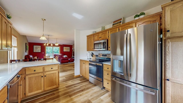 1057 John And Mary Dr SE, Chatfield, MN 55923 - kitchen featuring appliances with stainless steel finishes, light countertops, light wood-type flooring, pendant lighting, and a peninsula