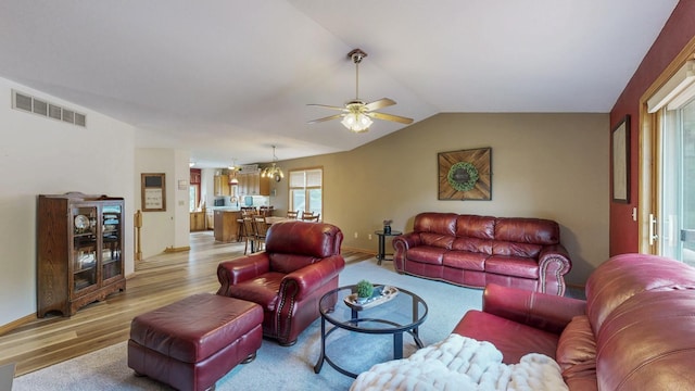 1057 John And Mary Dr SE, Chatfield, MN 55923 - living room featuring light wood-style floors, a ceiling fan, lofted ceiling, and a chandelier