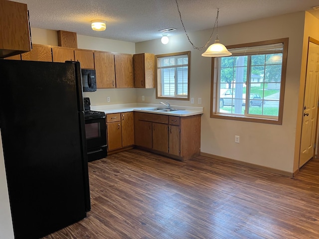 444 Terrace View Dr, Litchfield, MN 55355 - kitchen featuring black appliances, light countertops, dark wood-style floors, healthy amount of natural light, and a textured ceiling
