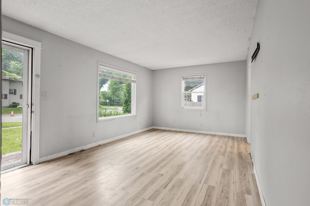 1709 13th Ave S, Fargo, ND 58103 - unfurnished room with a textured ceiling, plenty of natural light, and light wood finished floors