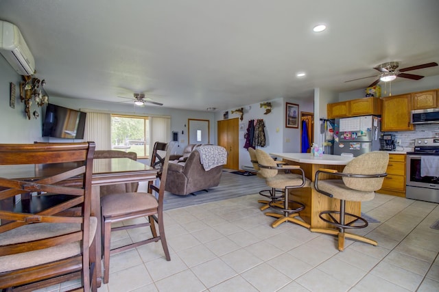111 W Ave, Ottertail, MN 56571 - kitchen featuring appliances with stainless steel finishes, a ceiling fan, a wall mounted air conditioner, light tile patterned floors, and light countertops