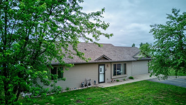 111 W Ave, Ottertail, MN 56571 - view of front facade featuring a front yard, concrete driveway, an attached garage, and roof with shingles