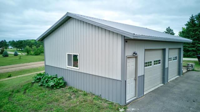 111 W Ave, Ottertail, MN 56571 - view of side of home with a garage, an outdoor structure, a metal roof, and a lawn