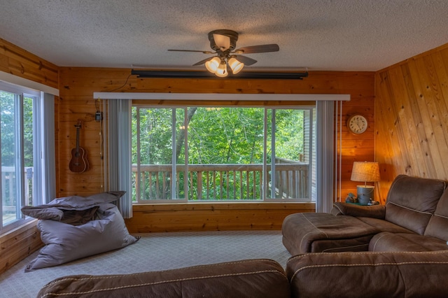 2507 Susans Is, International Falls, MN 56649 - carpeted living area featuring wood walls, a textured ceiling, and ceiling fan