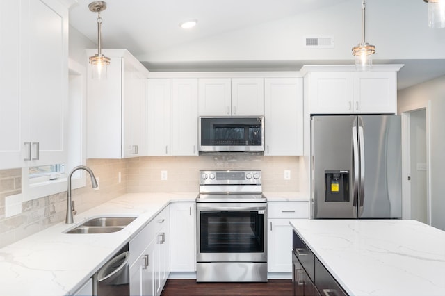 3829 Stebner Rd, Hermantown, MN 55811 - kitchen with stainless steel appliances, vaulted ceiling, white cabinetry, decorative backsplash, and pendant lighting