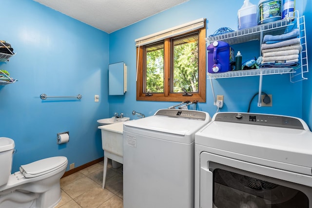 655 48th Ave, Goodview, MN 55987 - washroom featuring washer and clothes dryer, light tile patterned flooring, and a textured ceiling