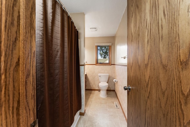 655 48th Ave, Goodview, MN 55987 - bathroom with a wainscoted wall, tile patterned floors, and a shower with shower curtain