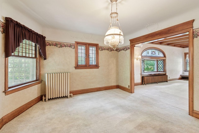 1323 Keston St, Saint Paul, MN 55108 - carpeted empty room featuring radiator heating unit, a chandelier, and beamed ceiling