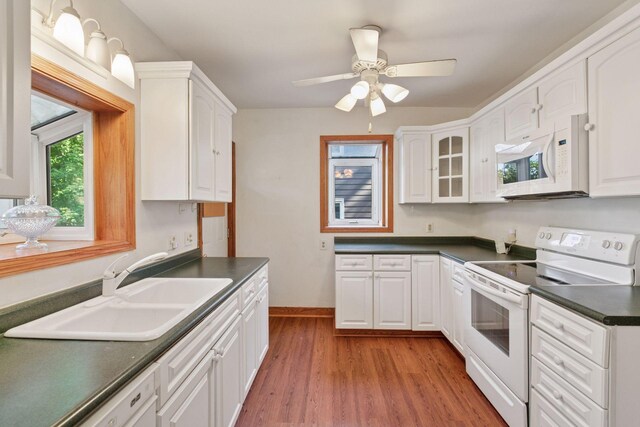 1323 Keston St, Saint Paul, MN 55108 - kitchen featuring white appliances, dark countertops, light wood finished floors, and white cabinets
