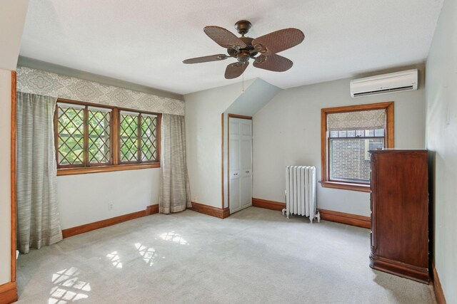 1323 Keston St, Saint Paul, MN 55108 - unfurnished bedroom with radiator heating unit, an AC wall unit, multiple windows, and carpet flooring