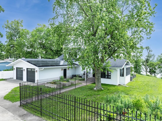 4255 County Road 11 NE, Alexandria, MN 56308 - view of front facade featuring an attached garage, roof mounted solar panels, driveway, a fenced front yard, and roof with shingles