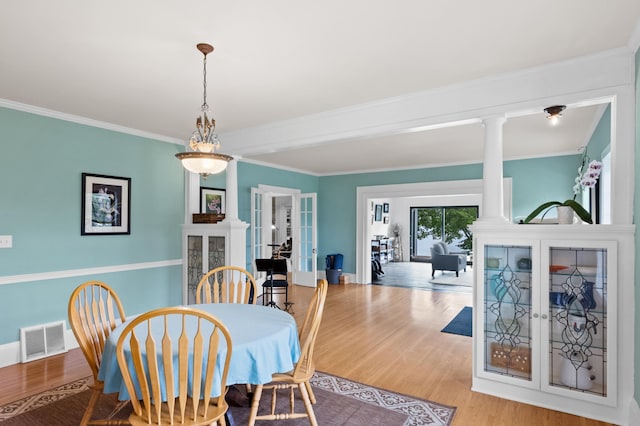 4255 County Road 11 NE, Alexandria, MN 56308 - dining space featuring french doors, ornate columns, wood finished floors, and crown molding