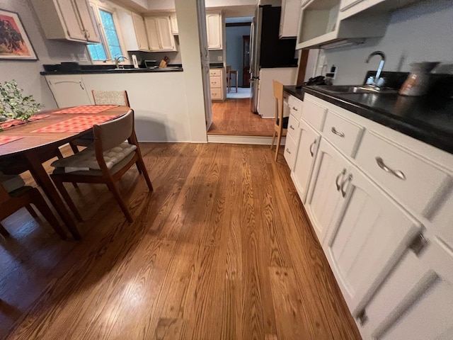 2700 Olde Wood Ct, Minnetonka, MN 55391 - kitchen with freestanding refrigerator, dark wood-style flooring, white cabinetry, and dark countertops