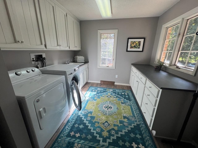 2700 Olde Wood Ct, Minnetonka, MN 55391 - laundry room featuring cabinet space, independent washer and dryer, wood finished floors, and a textured ceiling