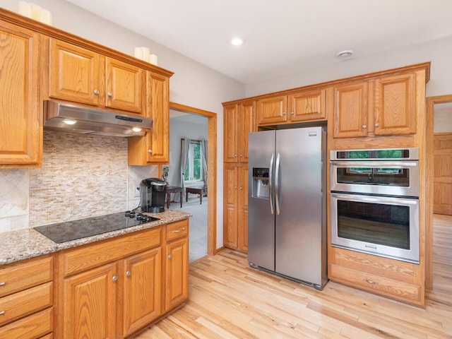 1632 Seashell Ln, Waconia, MN 55387 - kitchen featuring appliances with stainless steel finishes, under cabinet range hood, backsplash, light wood finished floors, and recessed lighting
