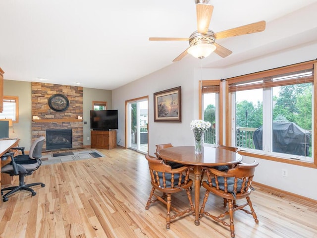 1632 Seashell Ln, Waconia, MN 55387 - dining area featuring light wood-style flooring, a stone fireplace, an office area, and ceiling fan