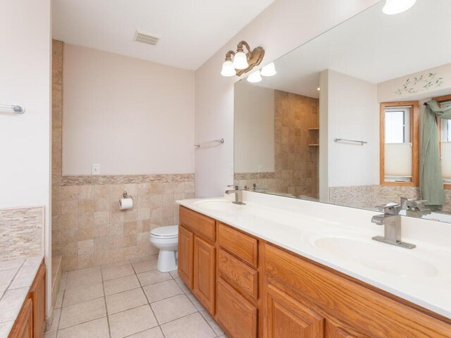 1632 Seashell Ln, Waconia, MN 55387 - bathroom with tile walls, double vanity, tile patterned floors, and wainscoting