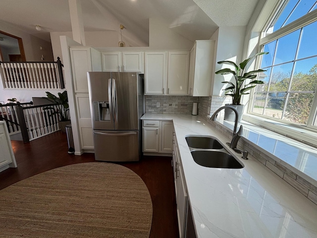 23120 Gardner Ave, Rogers, MN 55374 - kitchen featuring stainless steel refrigerator with ice dispenser, white cabinetry, decorative backsplash, dark wood-type flooring, and lofted ceiling