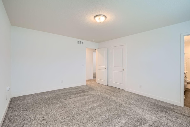 1221 136th St W, Rosemount, MN 55068 - unfurnished bedroom featuring carpet, ensuite bath, and a textured ceiling