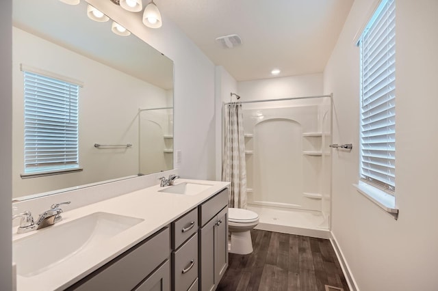 1221 136th St W, Rosemount, MN 55068 - bathroom with wood finished floors, curtained shower, double vanity, healthy amount of natural light, and recessed lighting