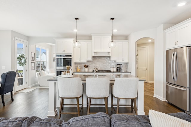 10914 23rd St NE, Saint Michael, MN 55376 - kitchen featuring appliances with stainless steel finishes, arched walkways, a breakfast bar, and recessed lighting