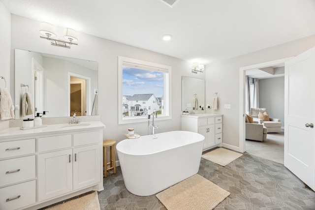 10914 23rd St NE, Saint Michael, MN 55376 - bathroom featuring two vanities, a freestanding tub, recessed lighting, and stone finish flooring