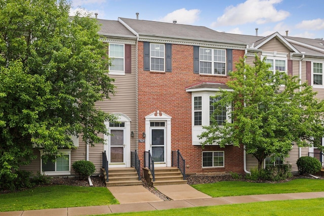 7829 Elm Grove Ln, New Hope, MN 55428 - colonial home with brick siding, a front yard, and entry steps