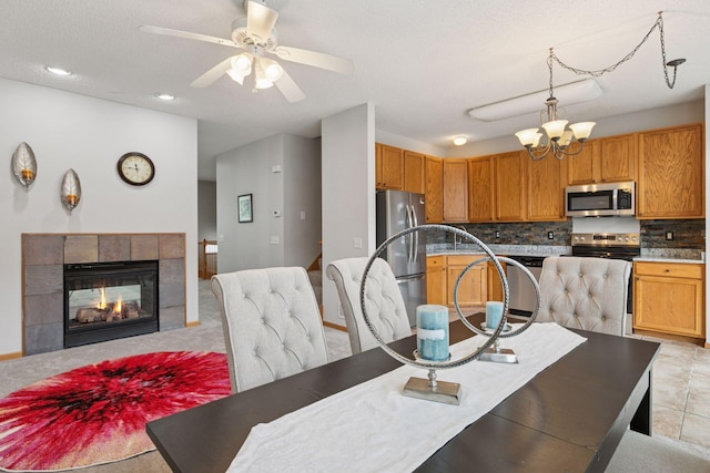 7829 Elm Grove Ln, New Hope, MN 55428 - dining room with a ceiling fan, a tiled fireplace, and a chandelier