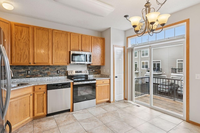 7829 Elm Grove Ln, New Hope, MN 55428 - kitchen with appliances with stainless steel finishes, backsplash, a chandelier, hanging light fixtures, and a textured ceiling