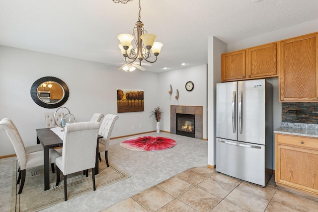 7829 Elm Grove Ln, New Hope, MN 55428 - dining space with light carpet, a chandelier, a fireplace, light tile patterned floors, and ceiling fan