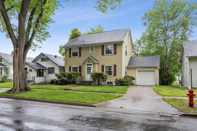 1330 12th St N, Fargo, ND 58102 - colonial home with concrete driveway, a garage, a front yard, and a shingled roof
