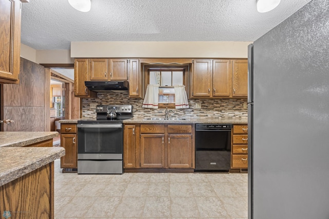1330 12th St N, Fargo, ND 58102 - kitchen featuring appliances with stainless steel finishes, under cabinet range hood, tasteful backsplash, a textured ceiling, and brown cabinets